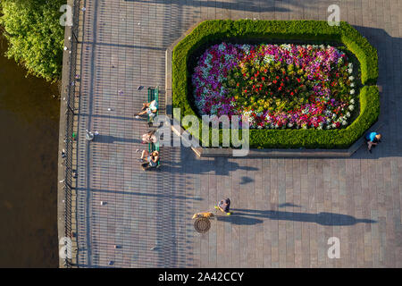 Vue de dessus des gens assis sur des bancs verts à côté de fleurs décoré de Prague en face du musée du Pont Charles Banque D'Images