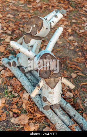 Figurines en bois de lapins de Pâques dans un parc forestier sur un fond de feuilles sèches. Deux lapins faites de branches de bouleau et bars, décoration de Pâques. Banque D'Images