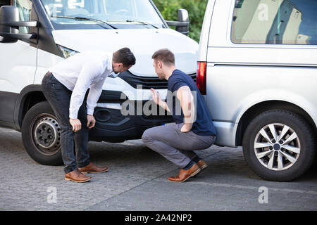 Close-up de deux hommes l'inspection de la voiture après l'accident pour les dommages Réclamation d'assurance Banque D'Images