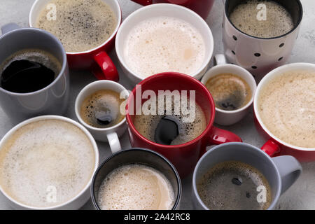Divers dans différentes tasses de café sur le fond gris béton Banque D'Images