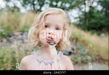 Fun portrait d'une jeune fille manger du chocolat et des guimauves Banque D'Images