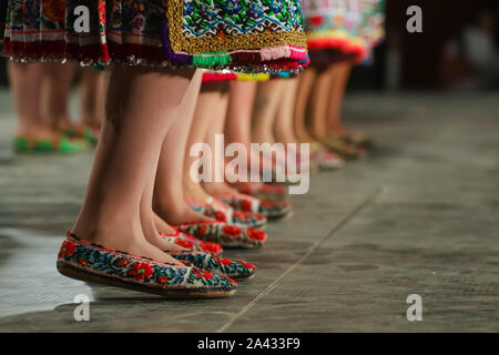 Close up de jambes de jeunes danseuses roumains en costume folklorique traditionnel. Le folklore de Roumanie Banque D'Images