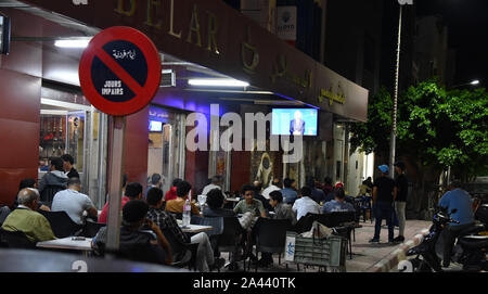 Peuple tunisien regardez la deuxième tour débat entre les candidats à la présidence Kais Saied 61, un conservateur indépendant, universitaires et magnat des affaires Nabil Karoui à Tunis. Banque D'Images