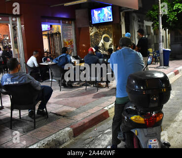 Peuple tunisien regardez la deuxième tour débat entre les candidats à la présidence Kais Saied 61, un conservateur indépendant, universitaires et magnat des affaires Nabil Karoui à Tunis. Banque D'Images