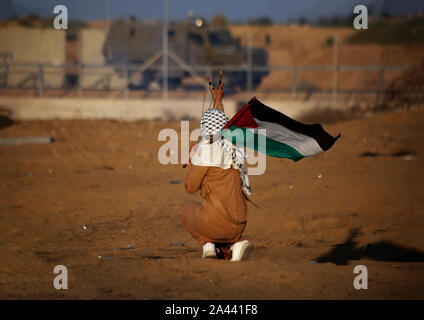 Un manifestant palestinien utilise une fronde pour lancer des pierres au cours d'une manifestation anti-Israël, appelant à mettre fin à des années de siège sur la frontière Israel-Gaza au sud de Gaza. Banque D'Images