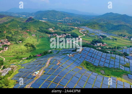 Tableaux de panneaux solaires sont installés à la friche sur une colline dans le village Huangsha, Zhuangkou ville, comté de Huichang, Ganzhou ville, est de la Chine Banque D'Images