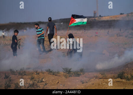 11 octobre 2019 - Gaza, Palestine. 11 octobre 2019. Un certain nombre de Palestiniens des manifestants sont blessés alors qu'ils entrent en conflit avec l'armée israélienne au cours de la 78 ème grande marche de protestation de retour à Abou Safiya, dans le nord de la bande de Gaza. Les Palestiniens de Gaza avaient recueillies à différents endroits près de la clôture de sécurité israélienne vendredi pour rejoindre la 78e année consécutive vendredi des manifestations hebdomadaires connu sous le nom de la grande marche du retour. Les protestataires ont soulevé la drapeaux palestiniens avec certains brûler des pneus et jeté des pierres en direction de la barrière et les soldats israéliens de l'autre côté. Les troupes israéliennes ont tiré des coups de feu Banque D'Images