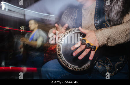 Close up de musicien dans les vêtements extravagants plaing sur tambour à main. Banque D'Images