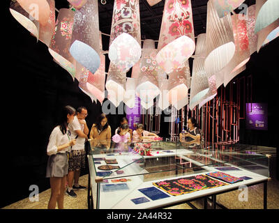 Les visiteurs voir une œuvre d'art avec des motifs décoratifs ethniques au cours d'une exposition au Musée d'Art de Beijing à Beijing, Chine, 7 août 2019. Banque D'Images