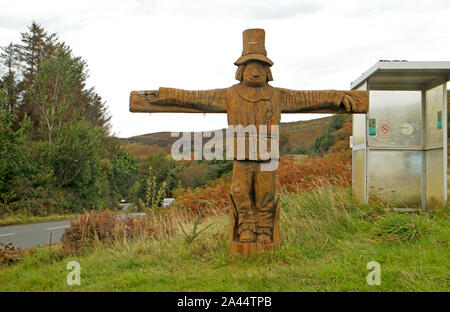 Une figure en bois sculpté et un arrêt de bus par la route à Drynoch863 sur l'île de Skye, Écosse, Royaume-Uni, Europe. Banque D'Images