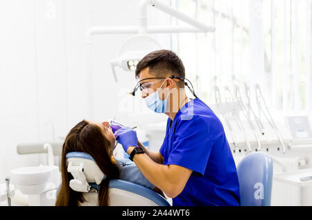 Dentiste de guérison d'une patiente dans une clinique dentaire. L'aide médicale et aux soins des dents. Banque D'Images
