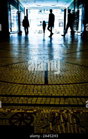 silhouettes de personnes marchant dans un passage souterrain Banque D'Images