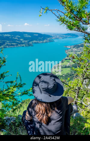 Fille avec un chapeau au mont Schoberstein relaxant et à la recherche jusqu'au lac Attersee (Dossier) dans les Alpes, Autriche Banque D'Images