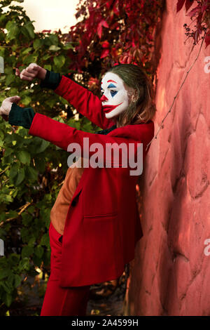Jeune femme avec Joker le maquillage et costume, danse Banque D'Images