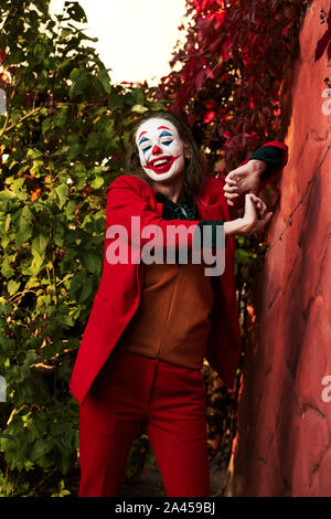 Jeune femme avec Joker le maquillage et costume, danse Banque D'Images