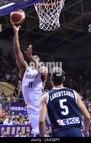 Un joueur de basket-ball de Venezuela, à gauche, saute pour une mise en place au cours de 2019 Suzhou Basketball Challenge International à l'encontre de la Grèce dans la ville de Suzhou, C'est Banque D'Images