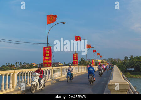 HOI AN, VIETNAM - 24ème Mars 2017 : les gens sur les scooters et motos de traverser un pont reliant à Hoi An à Cam Nam province au Vietnam. Banque D'Images