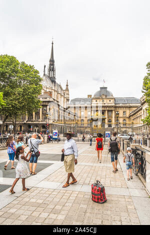 Les touristes de prendre des photos sur l'ile de la cité avec des palais de justice en arrière-plan Banque D'Images