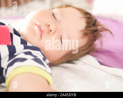 Bébé dort dans le lit des parents. les bras tendus du bébé un sommeil réparateur. close-up. l'enfant 0-1 ans. adorable lovely bébé dort calmement dans son lit, a un Banque D'Images