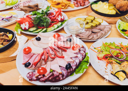 Bac alimentaire avec de délicieux morceaux de tranches de salami, du jambon, des saucisses et de la salade. Plateau de viande avec la sélection sur la table Banque D'Images