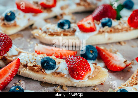 Banana Split Avec Fraises, Bleuets, beurre d'Amandes et miel Banque D'Images