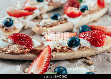 Banana Split Avec Fraises, Bleuets, beurre d'Amandes et miel Banque D'Images