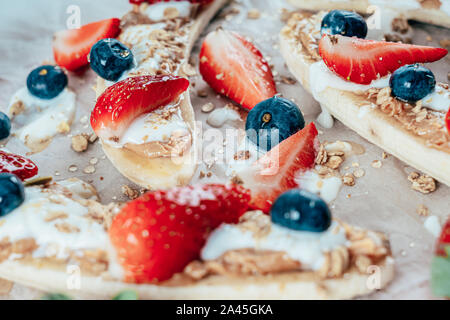 Banana Split Avec Fraises, Bleuets, beurre d'Amandes et miel Banque D'Images