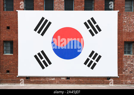 Drapeau sud-coréen géant sur le mur de briques rouges, un ancien hall de la prison de Seodaemun prison japonaise à Séoul en Corée du Sud Banque D'Images