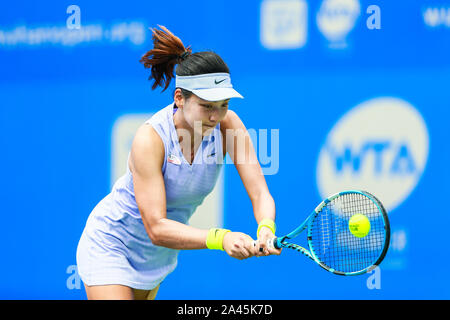 Xinyu Wang de Chine récupère la balle contre Kurumi Nara du Japon à la match de qualification des femmes simple de 2019 WTA Open de Wuhan à Wuhan, 100 Banque D'Images