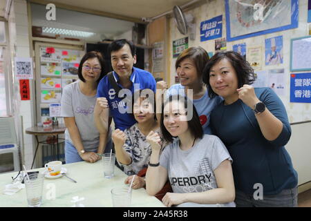 (191012) -- HONG KONG, le 12 octobre 2019 (Xinhua) -- Kate Lee (2e R, rangée arrière) pose pour une photo avec les clients à son plateau restaurant à Kowloon, Hong Kong, Chine du sud, le 10 octobre 2019. Niché dans les méandres du marché des fruits de mer de la paisible village de pêcheurs de Lei Yue Mun à Hong Kong, un peu de thé confortable restaurant a subitement devenir un phare de courage pour Hong Kong, les gens ordinaires à la recherche de la paix dans le récent chaos. Après avoir posté des photos de la sauvegarde de la police de Hong Kong contre certains manifestants radicaux à la fin du mois de juin, Kate Lee, le propriétaire de la plateau restaurant, trouvé sa conscience trop Banque D'Images