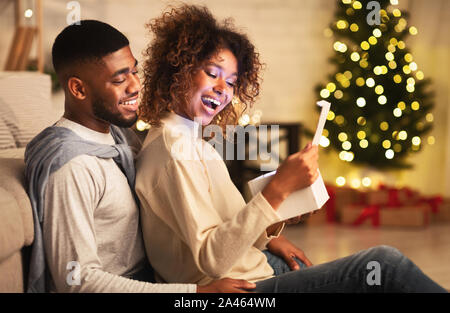Heureux couple afro-américains à la maison cadeaux de Noël Banque D'Images