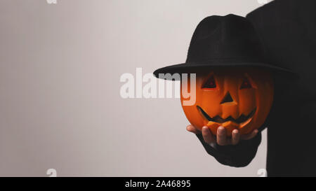 Jack o Lantern tenant sa tête de citrouille avec chapeau à la main Banque D'Images