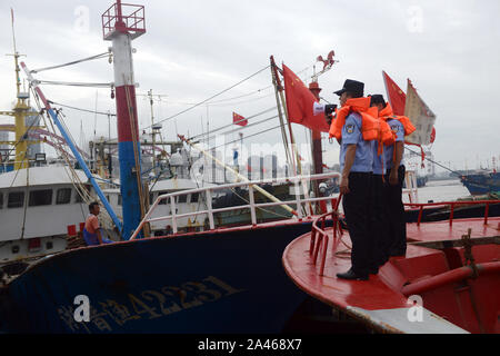 Aider les policiers les pêcheurs locaux à renforcer les bateaux de pêche et se préparer au prochain Typhon Mitag à Hefei City, Zhejiang Province de Chine orientale Banque D'Images