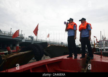 Aider les policiers les pêcheurs locaux à renforcer les bateaux de pêche et se préparer au prochain Typhon Mitag à Hefei City, Zhejiang Province de Chine orientale Banque D'Images