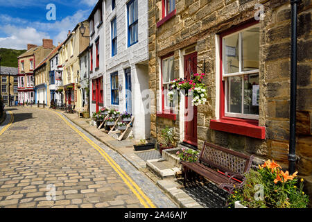 Bâtiments en pierre couleur soleil sur cobblestone High Street, dans le village balnéaire de Staithes North Yorkshire Angleterre Banque D'Images