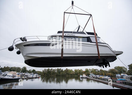 Hambourg, Allemagne. 12 octobre, 2019. Un yacht à moteur est soulevé hors de l'eau par une grue dans un yacht club. Crédit : Daniel Bockwoldt/dpa/Alamy Live News Banque D'Images