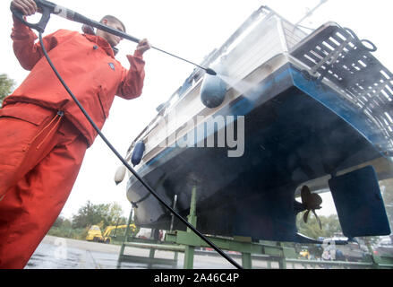 Hambourg, Allemagne. 12 octobre, 2019. Un yacht à moteur est nettoyé à l'aide d'un club de yacht et prêt pour l'hiver. Crédit : Daniel Bockwoldt/dpa/Alamy Live News Banque D'Images