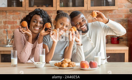 Heureux famille noire à jouer avec des petits gâteaux et de rire Banque D'Images