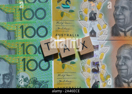 Dans l'impôt en bois 3D lettres alphabet sur fond d'une centaine de billets en dollars australiens. Banque D'Images