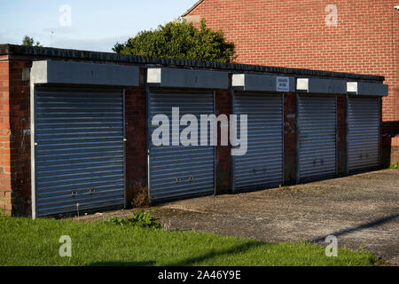 Le rouleau en acier jusqu'volets sur lock up local fermé garages sur une rue résidentielle Liverpool Angleterre UK Banque D'Images