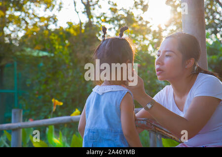 Jeune mère d'une petite fille pleurer apaisants, mère d'Asie pour le consoler et calmer son enfant qui pleure. Galerie d'images haute résolution. Banque D'Images