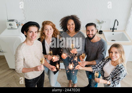 Young woman avec des flûtes de champagne et feux de Bengale mousseux Banque D'Images