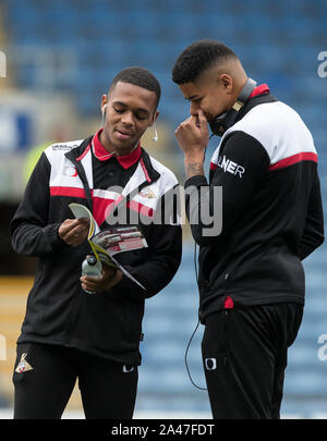 Oxford, UK. 12 octobre, 2019. Anthony Greaves (à gauche) & Demi Seny Dieng (prêt du Queens Park Rangers) de Doncaster Rovers regardez à travers le programme de jour de match match pré pendant le match de Ligue 1 pari du ciel entre Oxford United et Doncaster Rovers au Kassam Stadium, Oxford, Angleterre le 12 octobre 2019. Photo par Andy Rowland. Credit : premier Media Images/Alamy Live News Banque D'Images