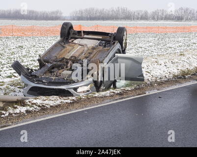 Annulée voiture à côté de la route mouillée par une journée d'hiver Banque D'Images