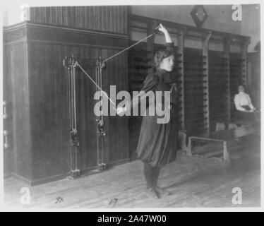 Étudiante l'entraînement avec un appareil fixé au mur à l'aide de cordes et de poulies, dans l'ouest de High School, Washington, D.C. Banque D'Images