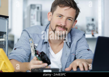 Heureux l'homme à la caméra à l'ordinateur après la fixation Banque D'Images