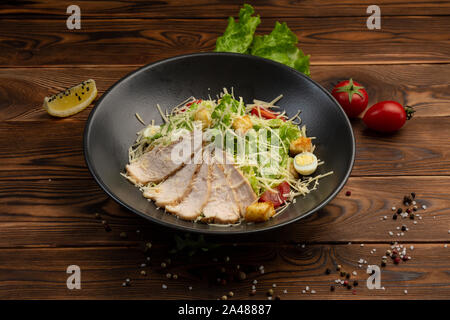 Caesar Salade de feuilles de San Romano, poulet à la pâte avec les tomates cerise, oeuf de caille, chapelure, parmesan, sauce caesar et tobiko Banque D'Images