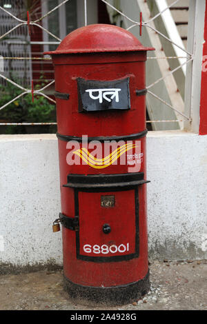 Kerala, Inde - Asie du sud-est de Letterbox:Indian Post / boîte / boîte ronde rouge indien ancien poste aux lettres à côté du bureau de poste, village rural Banque D'Images