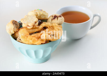 La rupture du jeûne de Yom Kippour avec divers mini cookies et une tasse de thé. L'Arabe des bonbons. Desserts du Moyen-Orient. L'henné fête des Cookies. Les sucreries marocaines. Mimouna Cookies. Banque D'Images