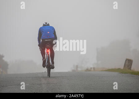 Flintshire, au nord du Pays de Galles, Royaume-Uni 13 octobre 2019. Météo France : Un déluge de pluies torrentielles se charge sur l UK avec de nombreuses parties en vertu des orages et dans certains endroits, le brouillard. La position d'un cycliste dans le brouillard près du village de Moel-y-Crio avec feux de vélo pour iluminated DGDImages AlamyLiveNews/sécurité © Banque D'Images